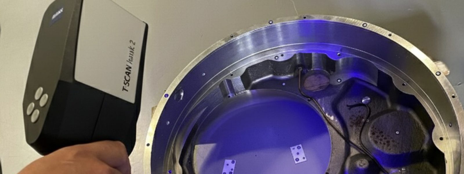 ZEISS T-SCAN hawk 2 mobiler 3D-Handscanner beim Vermessen eines Bauteils mit blauen Streifenlichtprojektionen — kabellos, EU-weit vor Ort einsetzbar