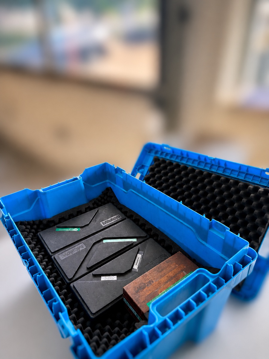 Geöffnete Versandbox mit stoßsicher in Schaumstoff gepackten Mess- und Prüfmitteln — transportsicheres Verpackungssystem der 3D Messtechnik KMK GmbH